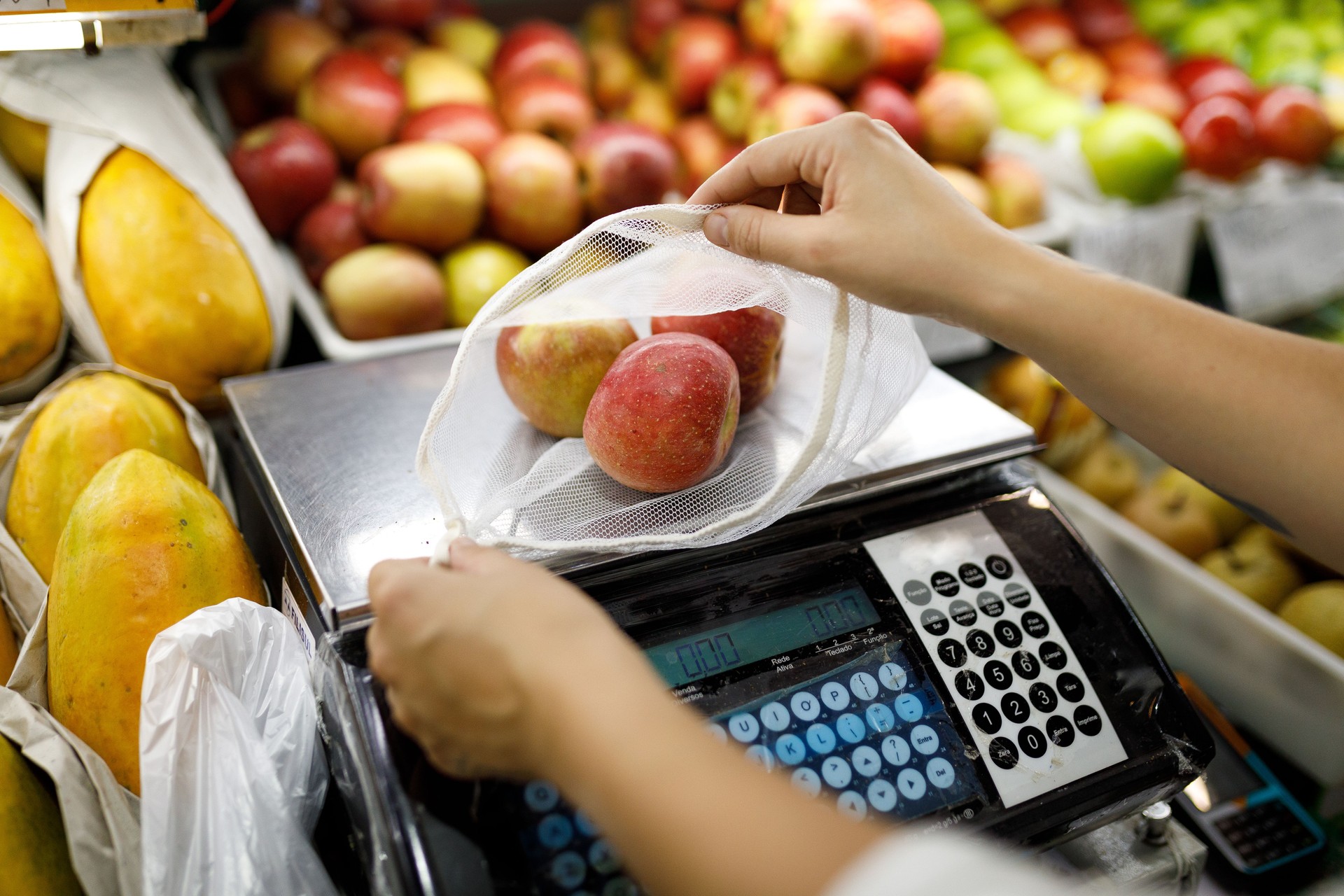 Woman weighing apples on digital scale